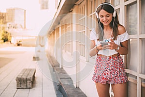 Happy young woman listening to music on the mobile phone