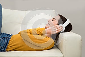 Happy young woman listening to music, using wireless headphones