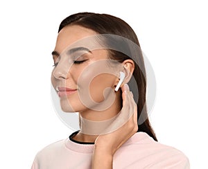 Happy young woman listening to music  wireless earphones on white background