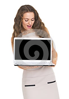 Happy young woman looking on laptop blank screen