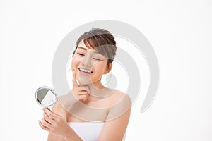 Happy young woman looking on mirror