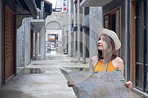 Happy young woman lost in the city holding map. Travel tourist Asian girl with map. Travel journey concept