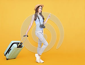 Happy young woman with  luggage and camera  on yellow background ,summer,travel concept