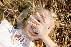 Happy young woman lying on cereal field