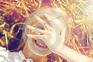 Happy young woman lying on cereal field