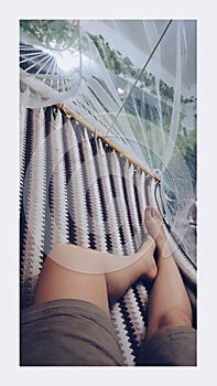 Happy young woman lying on a hammock and relaxing photo