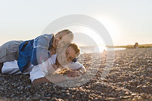 Happy young woman lying on her boyfriends back, looking at camera, having fun together.