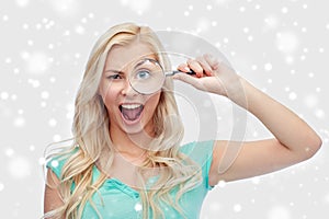 Happy young woman with magnifying glass