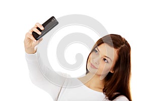 Happy young woman makes selfies with smart phone