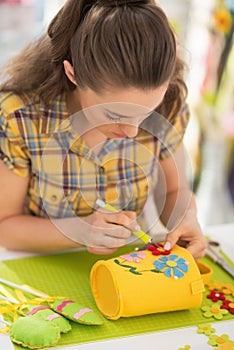 Happy young woman making easter decoration