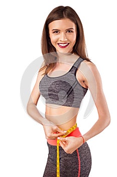 Happy young woman with measure tape, fitness concept