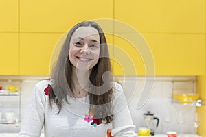 Happy young woman in a modern new kitchen. Happy young woman with long hair