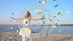 Happy young woman and money falling from sky.