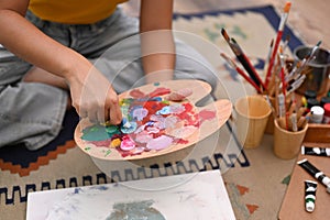 Happy young woman painting picture with watercolor at cozy home. Art, creative hobby and leisure activity concept