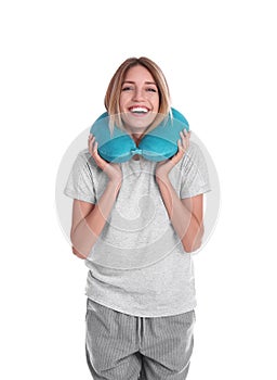 Happy young woman in pajamas with neck pillow on white