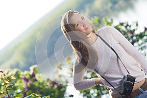 Happy young woman photographer using old camera