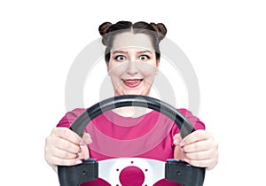 Happy young woman in pink t-shirt with steering wheel, isolated on white background. Front view. Female car driver concept