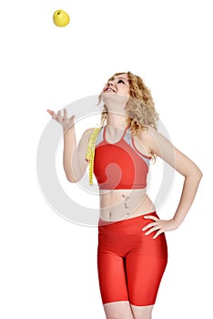 Happy young woman playing with green apple