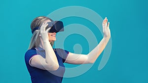 Happy young woman playing on VR glasses indoor. Virtual reality concept with young girl having fun with headset goggles photo