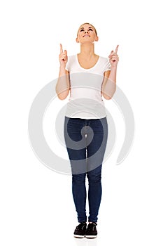 Happy young woman pointing up with both hands