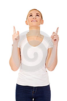 Happy young woman pointing up with both hands