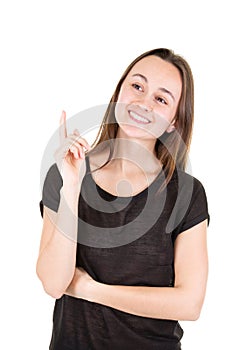 Happy young woman pointing upwards looking in camera
