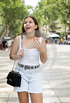 Happy young woman posing cheerfully in Rambla Street of Barcelona