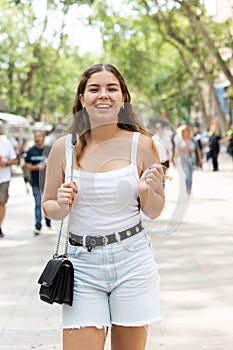 Happy young woman posing cheerfully in Rambla Street of Barcelona
