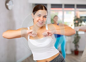 Happy young woman practicing aerobics in light fitness studio