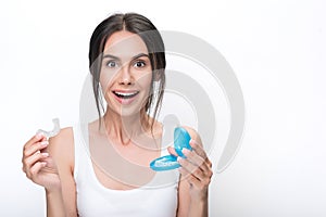 Happy young woman presenting clear aligners photo