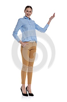 Happy young woman presenting to side on white background