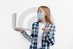 Happy young woman, in protective mask, waving hand, holding laptop social distance call, on white background