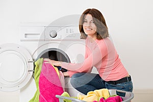 Woman Putting Clothes Into Washing Machine