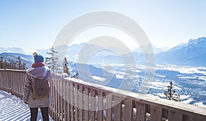 Happy young woman is raising her hands on the mountain, enjoying the view over Salzburg. Winter time on Gaisberg, Salzburg,