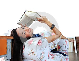 Happy young woman reading a book at home