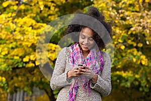 Happy young woman reading text message on mobile phone