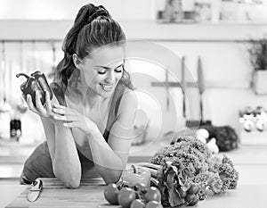 Happy young woman ready to make fresh vegetable sala