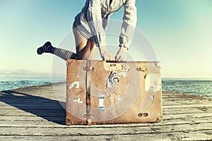 Happy young woman ready to travel with her suitcase