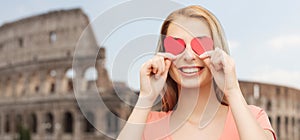 Happy young woman with red heart shapes on eyes