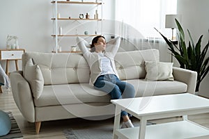 Happy young woman relax on couch at home