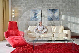 Happy young woman relax at home on sofa