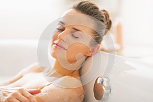 Happy young woman relaxing in bathtub