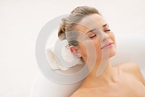 Happy young woman relaxing in bathtub