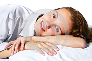 Happy young woman relaxing in bed