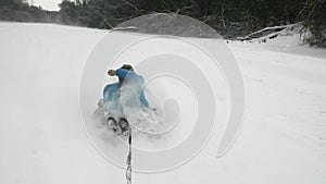 Happy young woman ridet on snowtube behind the ATV Quad bike