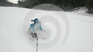 Happy young woman ridet on snowtube behind the ATV Quad bike