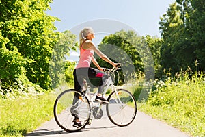 Happy young woman riding bicycle outdoors