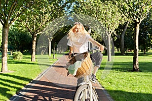 Happy young woman riding bike on road in park, beautiful hipter teenager having fun and laughing