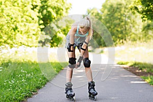 Happy young woman in rollerblades riding outdoors