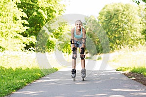 Happy young woman in rollerblades riding outdoors